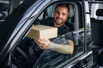 The delivery man or a loader is in the car with box