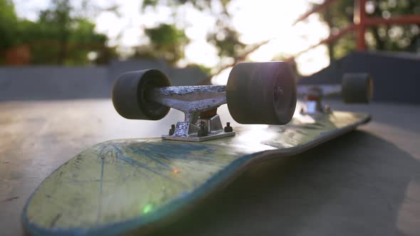 Closeup Shot of Skateboard on the Ground in Sun Beams