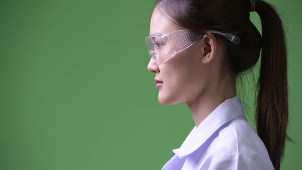 Profile View of Young Beautiful Asian Woman Doctor Wearing Protective Glasses