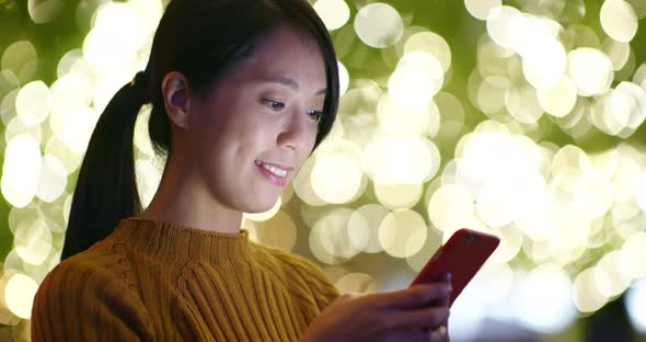 Woman use of cellphone with Christmas decoration 