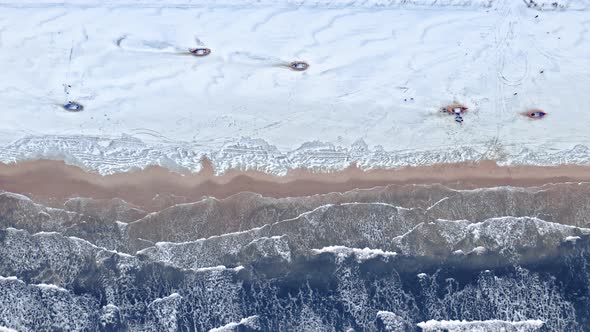 Boats on snowy beach in winter at Baltic Sea.