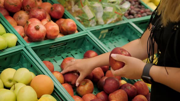 Closeup of a Young Woman Choosing Fresh Fruit in a Grocery Stores