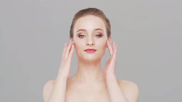 Studio portrait of young, beautiful and natural woman over grey background.