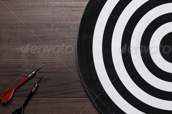 Two Darts And Target On Wooden Background
