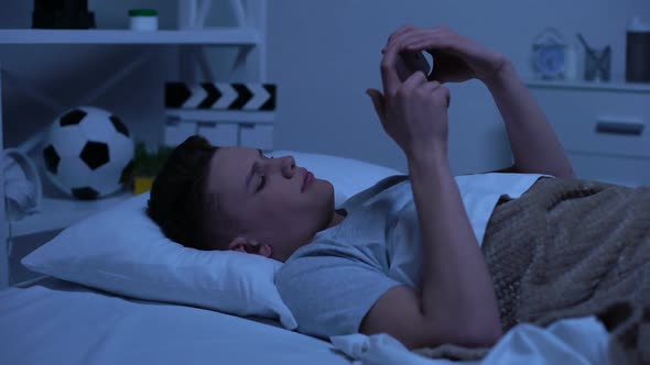 Teenager Scrolling Smartphone, Putting It in Bed and Falling Asleep, Relaxation