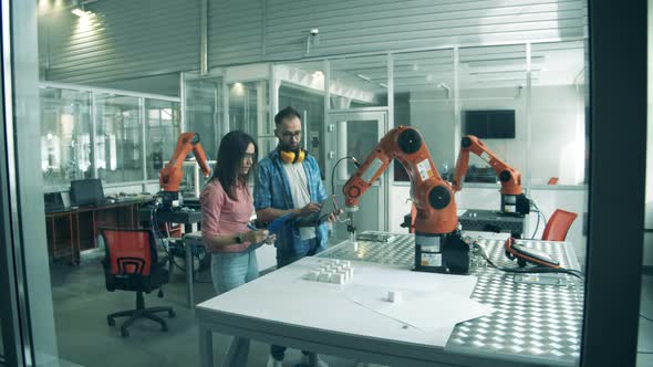 Workers Check Robotic Arm in Action. Innovation, Hi-tech Education, Science Studying Concept