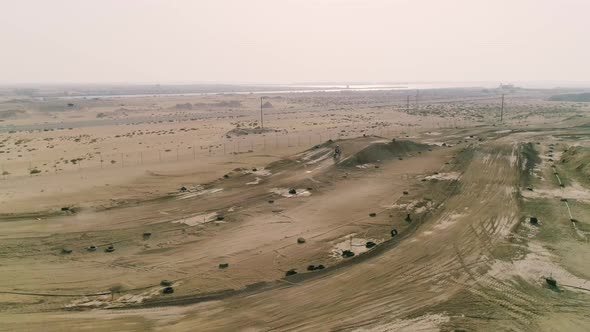 Aerial view of man practicing motocross at desert landscape, U.A.E.