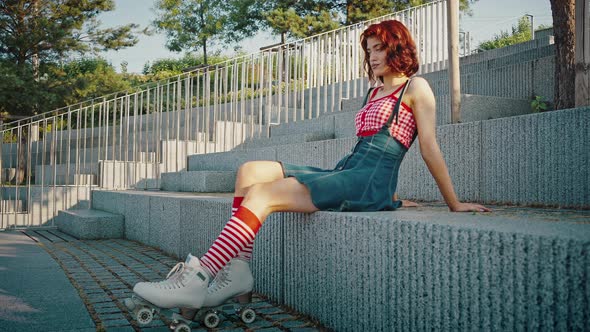 Outdoor Portrait of Young Lady Roller Skater in Squads Resting in Urban Park Preparing for Activity