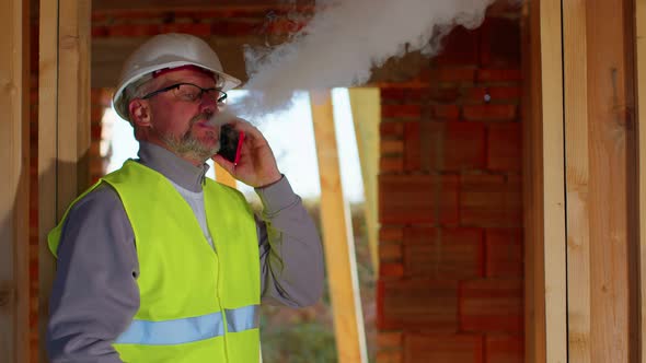 Professional Builder Architect Talking on Mobile Phone to Control Working at Construction Site