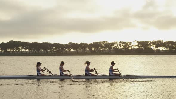 Female rowing team training on a river