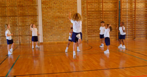 Basketball coach teaching basketball to schoolkids in basketball court 4k