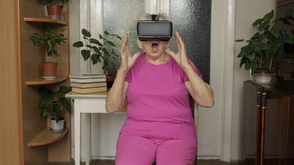 Senior Grandmother Putting on Virtual Headset Glasses and Watching 3d Video in 360 Vr Helmet at Home