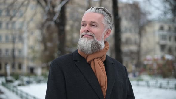 Adult gray-haired man with beard enjoying a cool winter morning