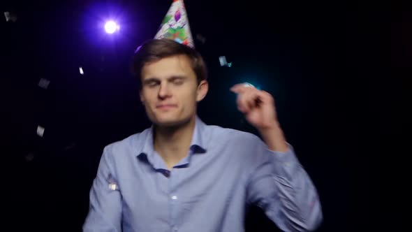 Guy Throwing Glitter Confetti, Blowing Party Whistle and Dance. Close-up