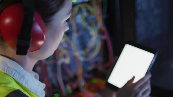 Caucasian female it technician using tablet with blank screen checking computer server