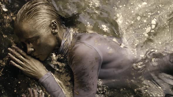 Woman Dancer in Water Face and Hair Covered Golden Shiny Dye Moving Gracefully and Slowly