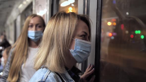 Two Blonde Women in Medical Masks Riding in Metro