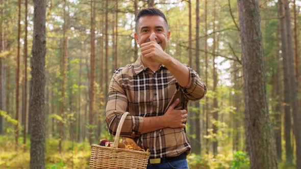 Man with Mushrooms Showing Thumbs Up in Forest