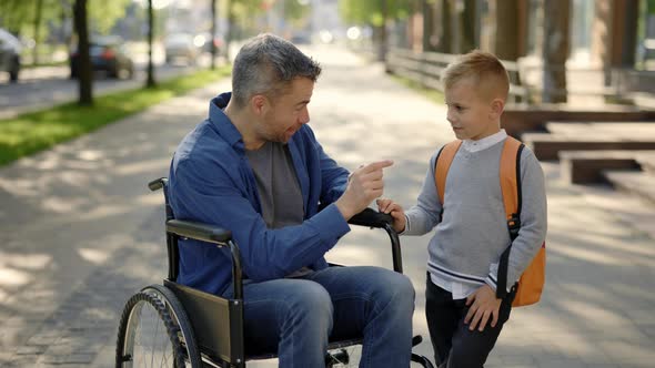 Disabled Father Tells His Son a Story and Fixing His Backpack After School