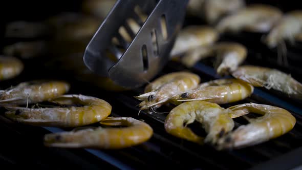 Tongs for grilling uncover grilled shrimps