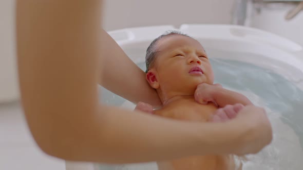 Calm of asian newborn baby bathing in bathtub