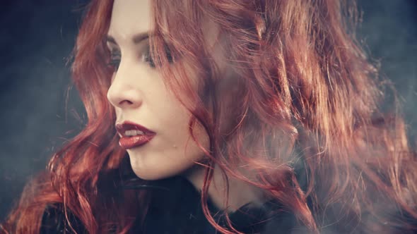 Portrait Witch Witch with Red Hair and Devil Horns. Woman Smiling Devilishly and Cast a Spell