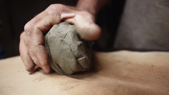 Potter Kneads Clay with One Hand on Table with Special Napkin and Prepares It for Use in Production