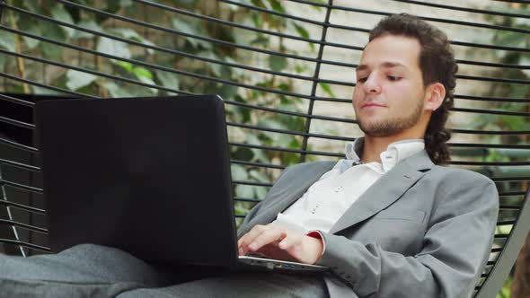 Young successful caucasian businessman works in a lounge using a computer.