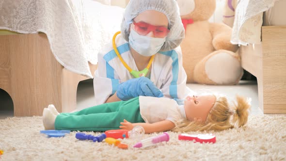 Beautiful Little Girl Playing Doctors with Doll at Home