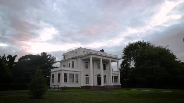 Time-lapse of colorful clouds passing over a late 18th century victorian manor estate.