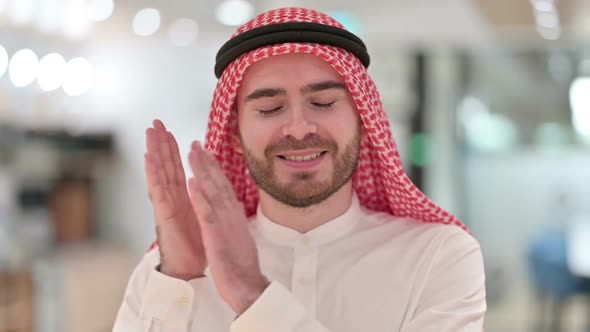 Portrait of Excited Arab Businessman Clapping Cheering