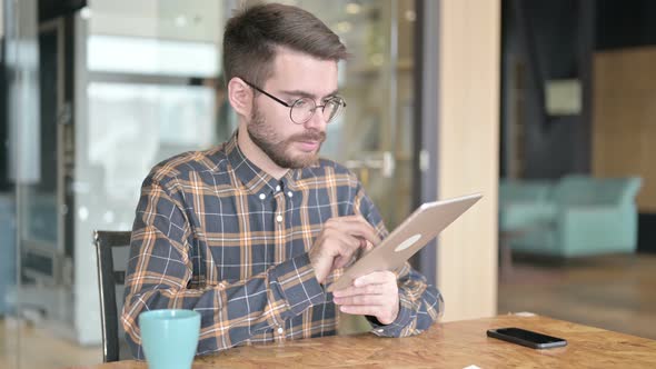 Focused Young Designer Using Tablet in Modern Office