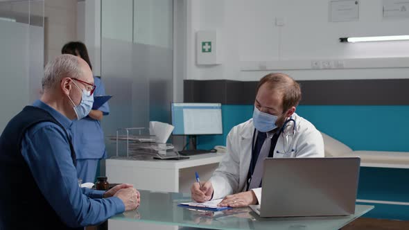 Health Specialist Giving Prescription Paper to Senior Patient