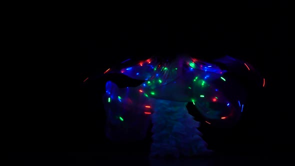 Belly Dancer Girl Dance with Two Glowing Lights Wings. Black Background. Sihouette
