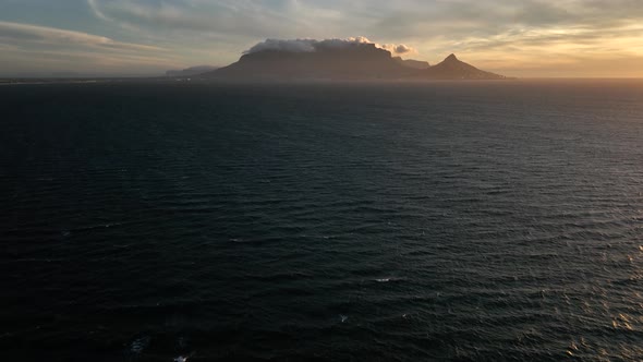 Epic cinematic drone reveal shot over Atlantic of iconic Table Mountain