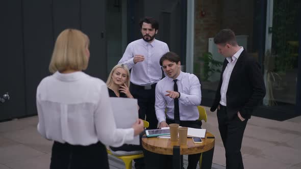 Group Confident Business People Gesturing Brainstorming on Office Terrace As Woman Standing with