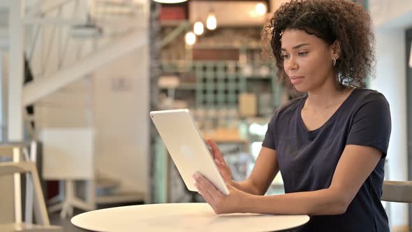 Success, Young African Woman Celebrating on Tablet in Cafe 