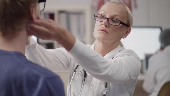 Close Up of Mature Doctor Examine Patient During Check Up in Hospital