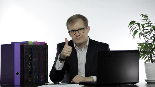 Happy Businessman Manager Giving Thumbs Up Sitting at Office Table