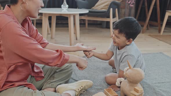 Asian Boy Playing with Mom in Living Room