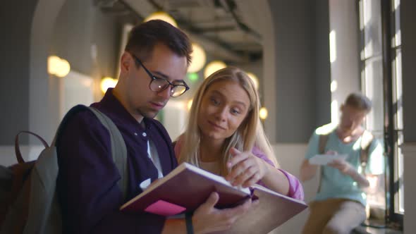 Portrait of Two Students Reading Notebook in Corridor Preparing for Exam