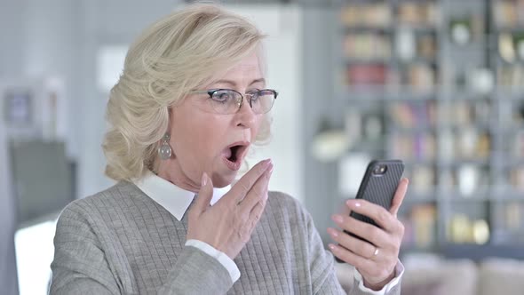 Portrait of Sad Old Woman Reacting To Loss on Smartphone