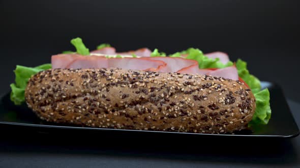 Tasty sandwiches rotating on dark background, close up