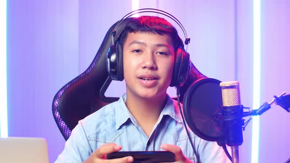 Asian Kid Boy Holding Mobile Phone And Talking To Camera While Live Stream