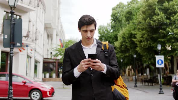 Young Businessman Walking Down on the Street 