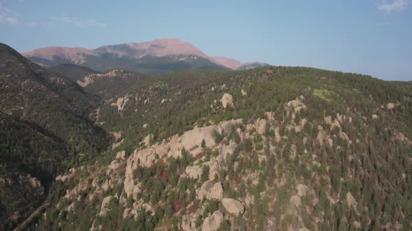 Aerial dolly in over rugged Colorado mountains, looking towards Pikes Peak.