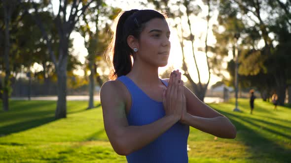 A beautiful and happy young hispanic woman yogi smiling in a meditation yoga session in prayer pose