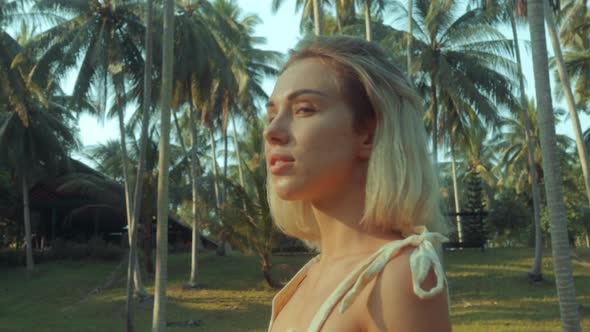 Young Blonde Standing Contemplating Tropical Rainforest Sunset Light Coming From Above