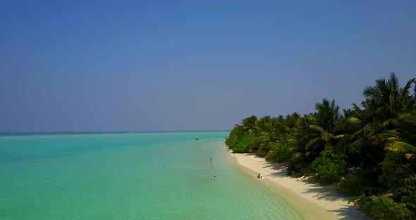 Beautiful fly over copy space shot of a sandy white paradise beach and blue ocean background in colo