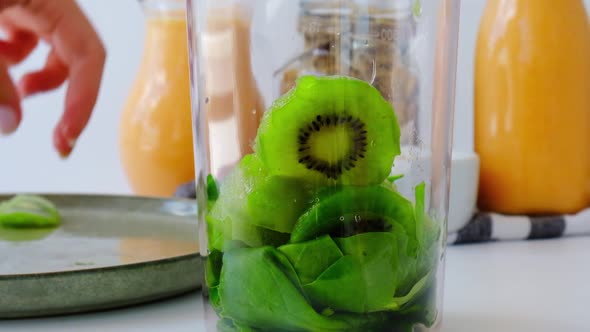 Slow Motion Woman Cooking Healthy Smoothie Add Green Apple Kiwi Spinach Blended in Blender Green